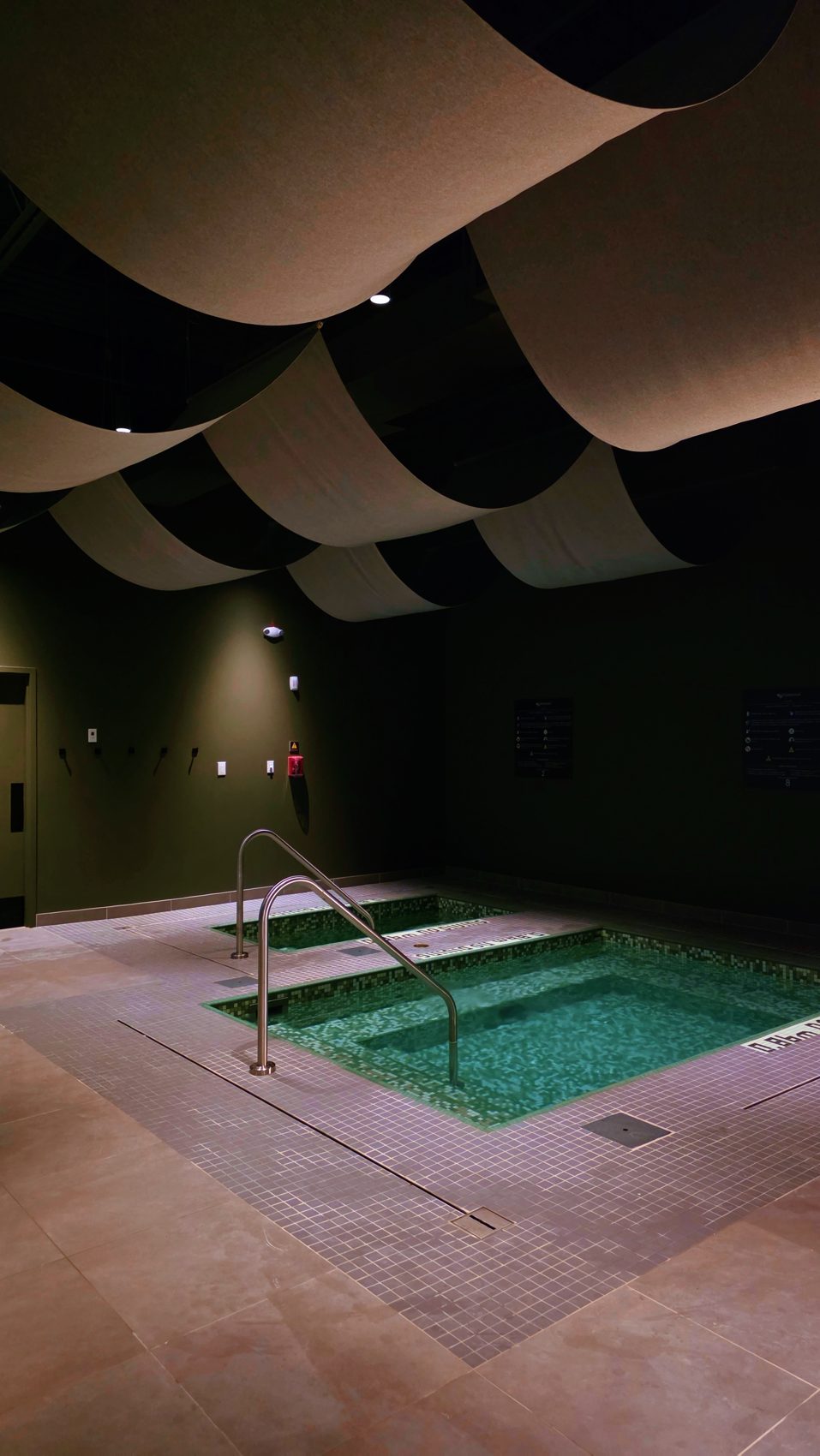 Cold plunge pool beneath a sculpted wave ceiling